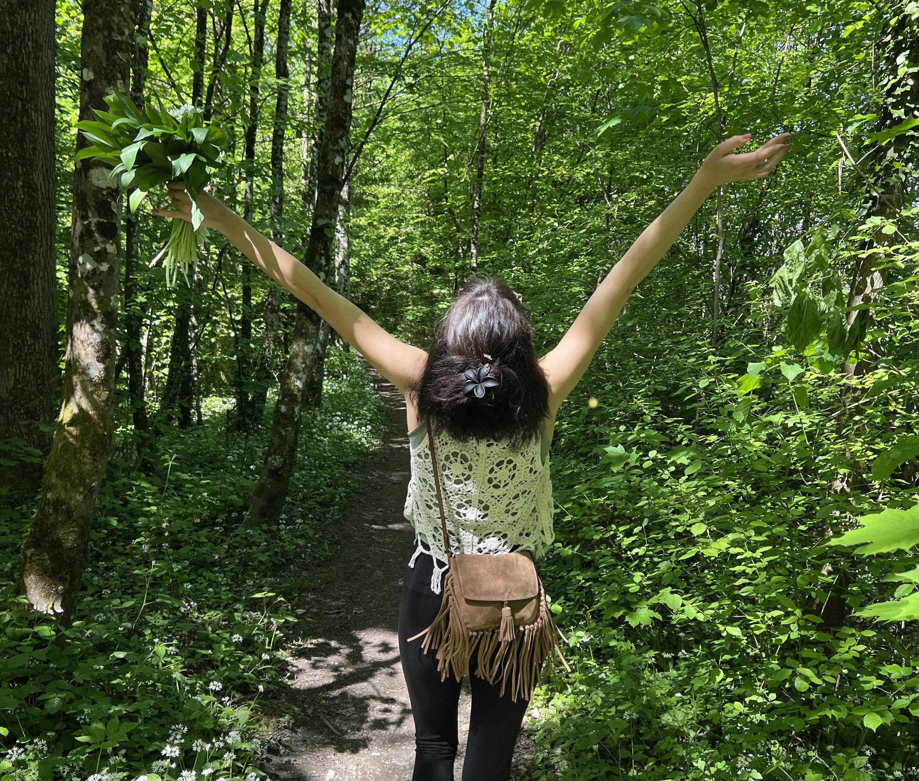 Sophie läuft durch den Wald mit einem Bündel Bärlauch in der Hand.
